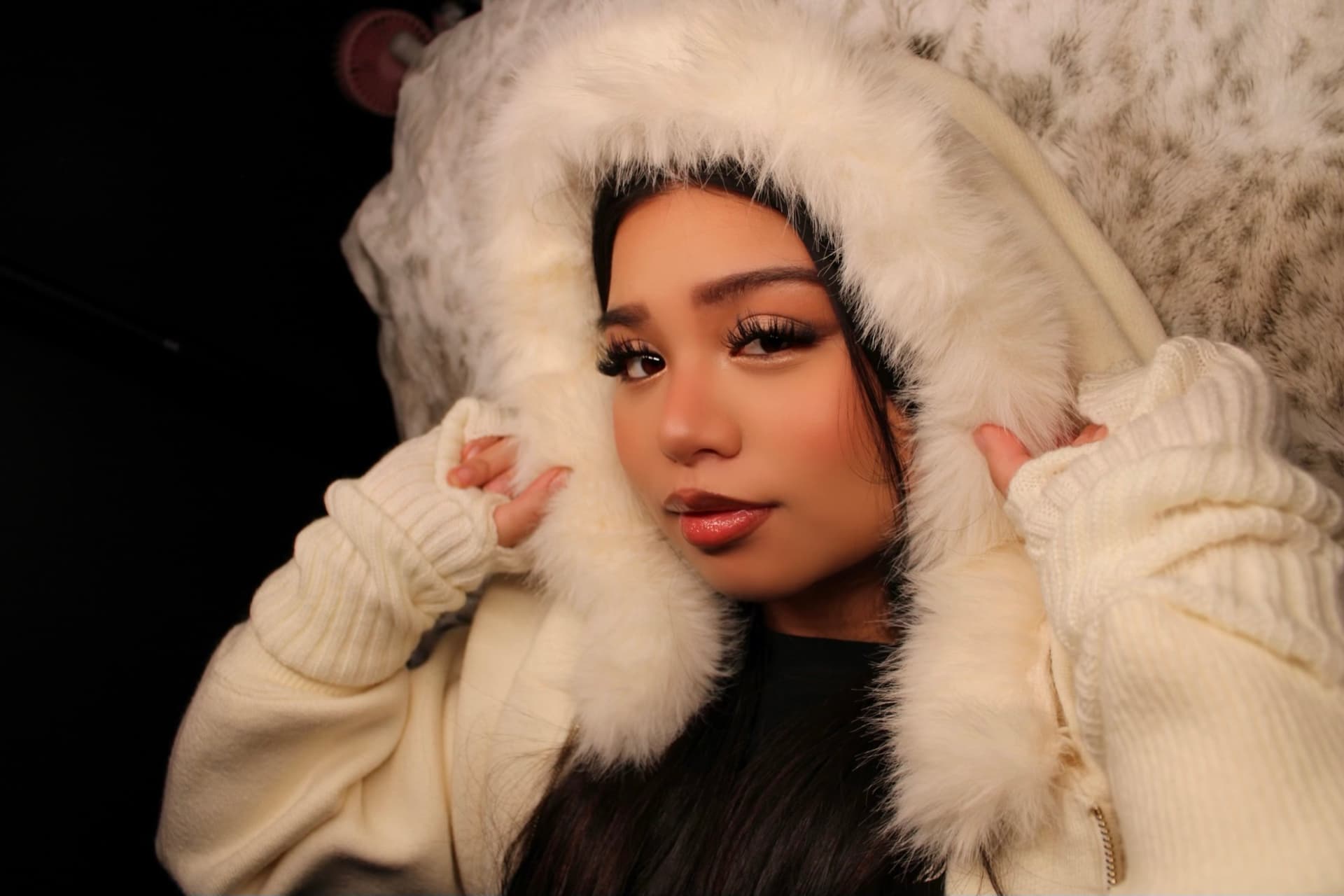 Model in a cream fur hood wearing the Snowy Angel lash set